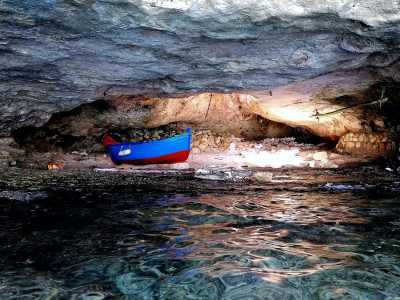 La caverna, illuminata unicamente dall�entrata e da un foro sulla parete superiore protetto da una grata in ferro, � dominata al centro da una piccola barchetta: un gozzo colorato di rosso e blu �attraccato� alla parete attraverso una lunga catena
